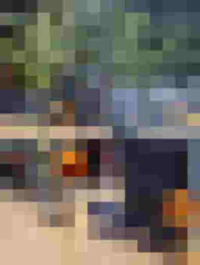 Drei bunte Cocktails auf Rooftop-Tisch mit Alpenblick