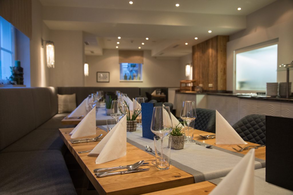 modern gedeckter Restauranttisch mit Stoffservietten und Weingläsern